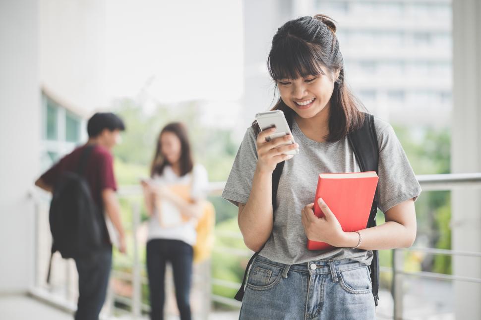 Free Image of Happy student looking at her phone 