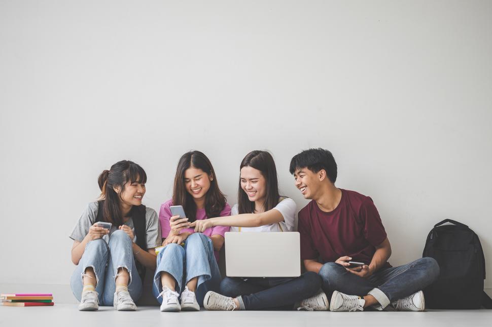 Download Free Stock Photo of Group of happy students looking at social media 