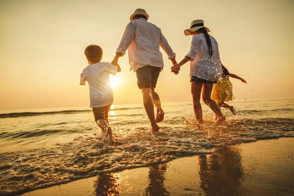 Free Image of Happy family enjoying the sunset play on the beach 