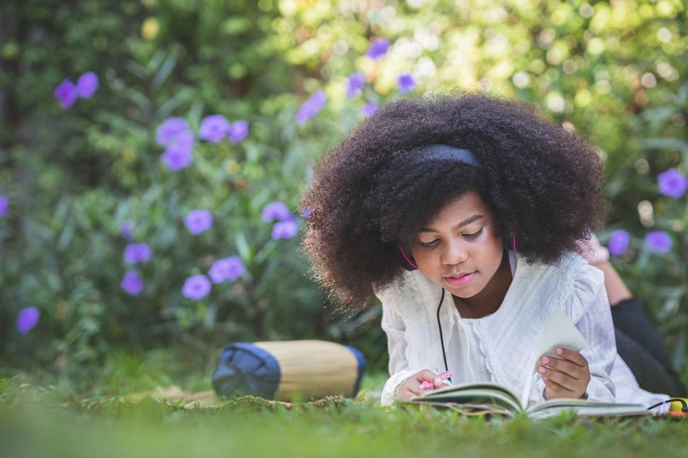 Free Image of Little girl reading at the park 