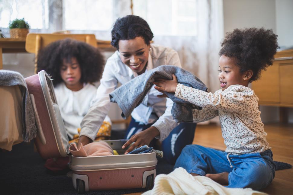 Free Image of Family packs clothes into a suitcase 