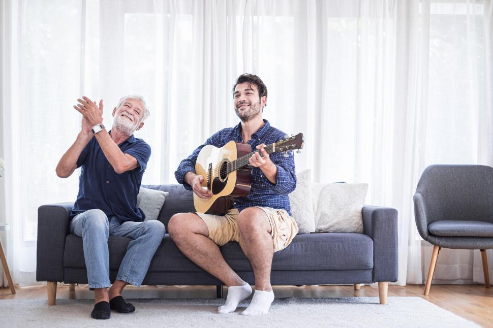 Free Image of Old senior man and son are enjoying guitar music together 