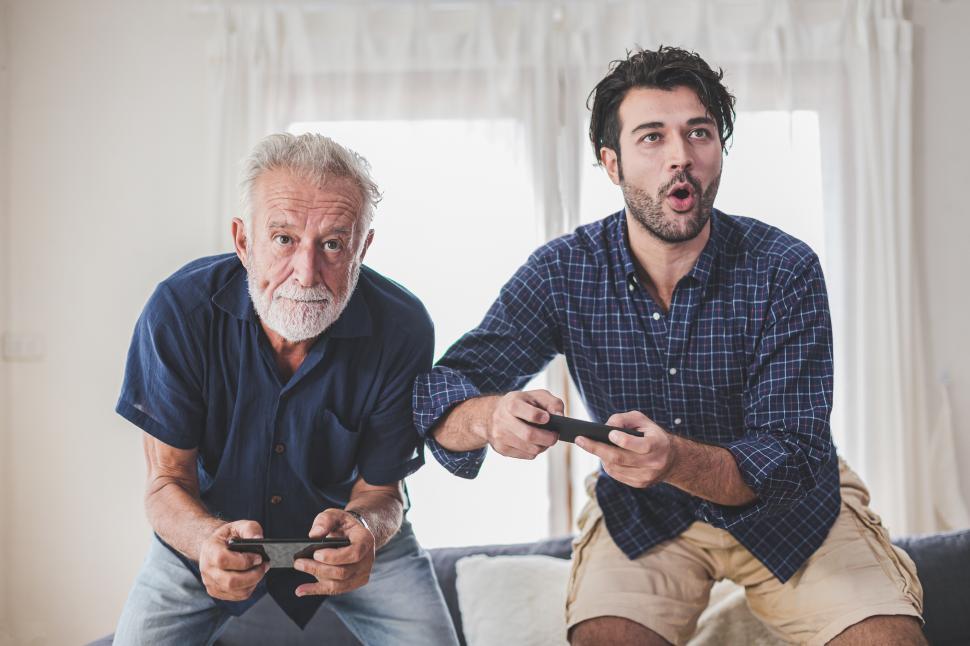 Free Image of Man playing video games with his older father 