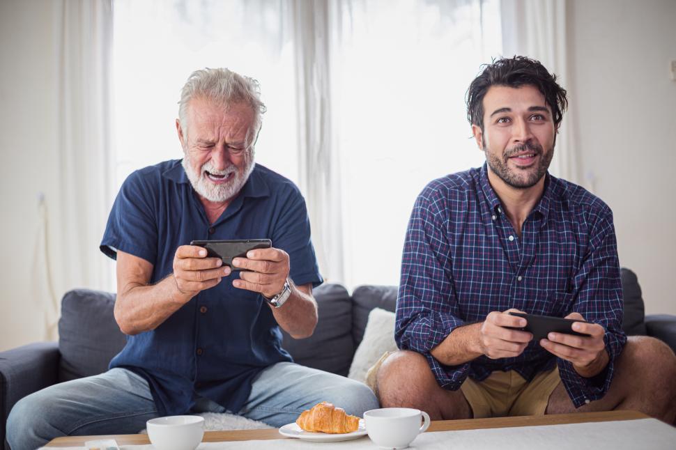 Free Image of Adult man and his father playing mobile video games 