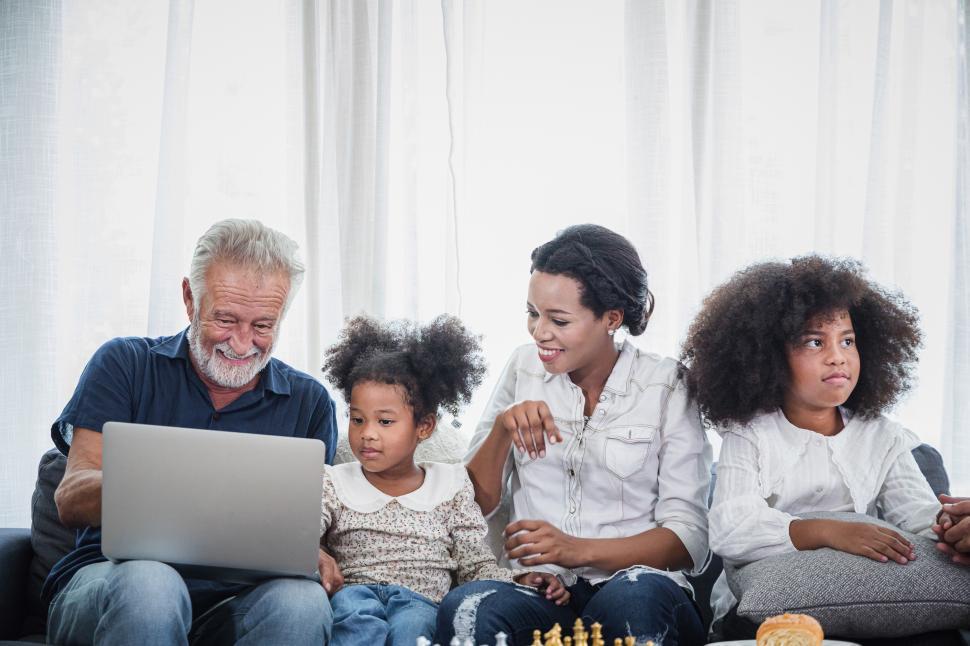 Free Image of Cheerful young family with children laughing watching videos on laptop 
