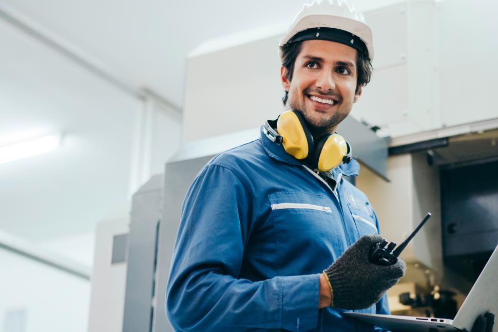 Free Image of Male industrial engineer holding radio phone and laptop 