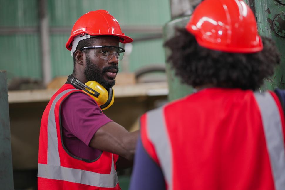 Free Image of Two factory workers interact 