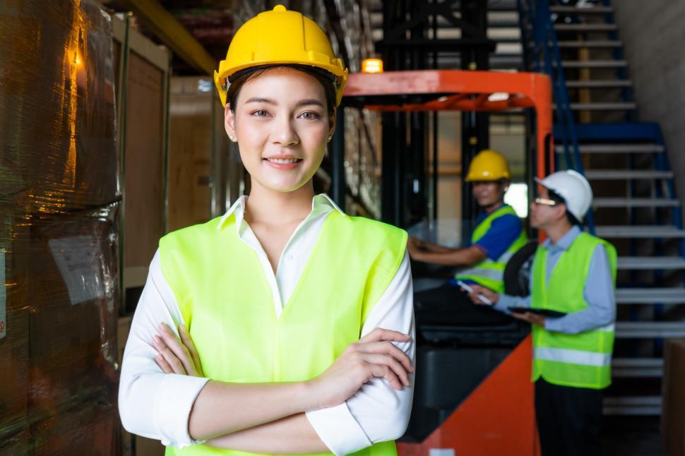 Free Image of Portrait of warehouse woman worker smile with arms crossed 