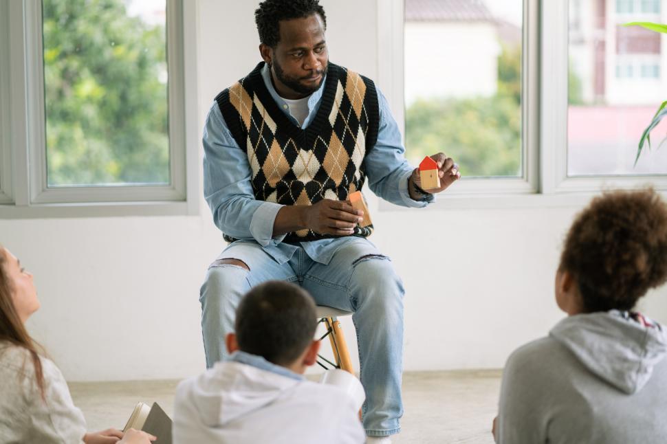 Download Free Stock Photo of African American teacher teaching small group  