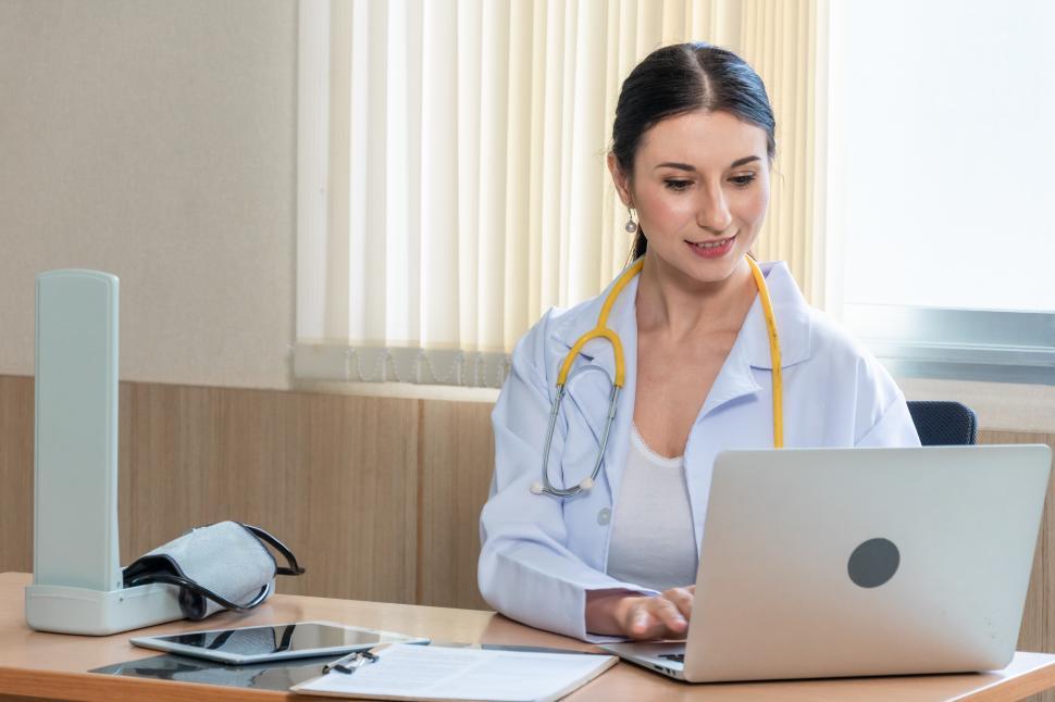 Free Image of Female doctor using laptop to work or read medical report 