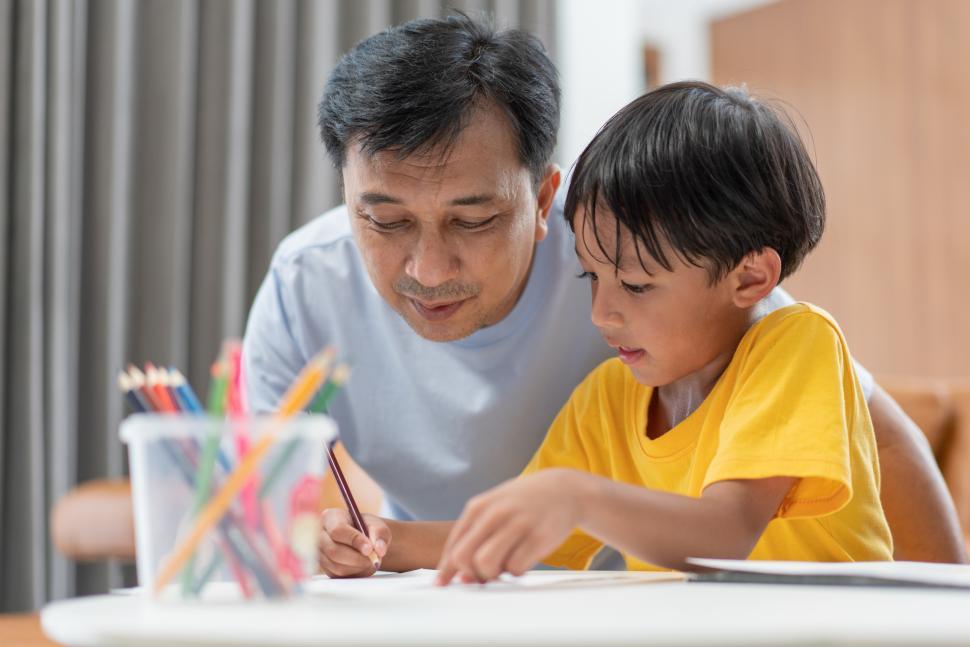 Free Image of Father teaching and helping son to do homework at home 