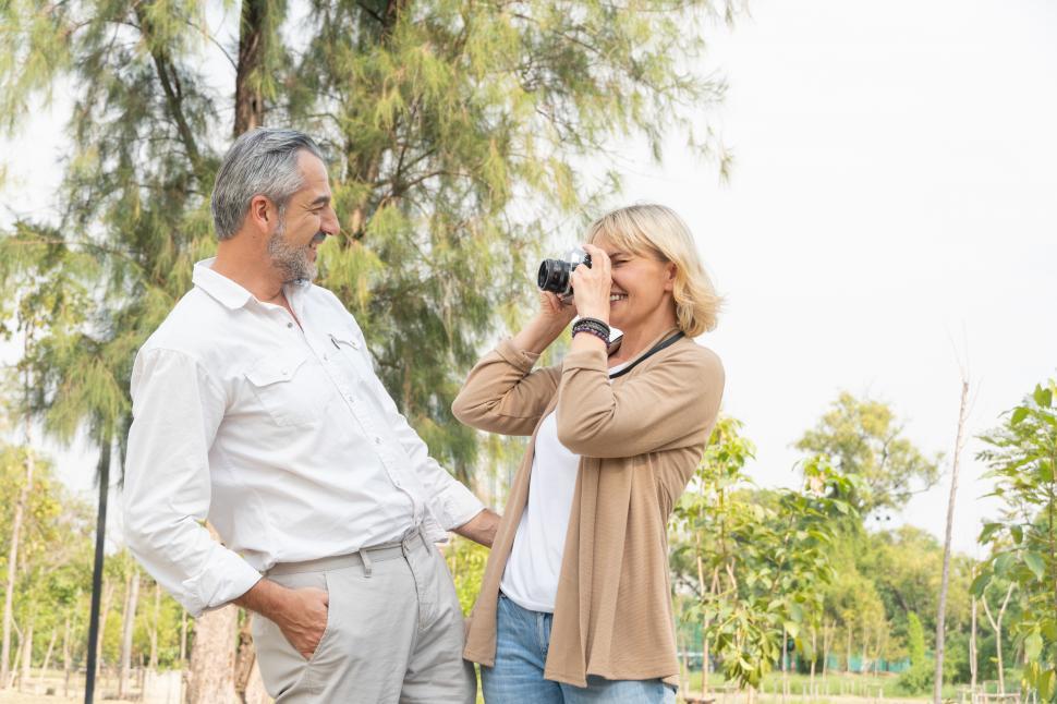 Free Image of Woman using vintage camera taking picture of her man 