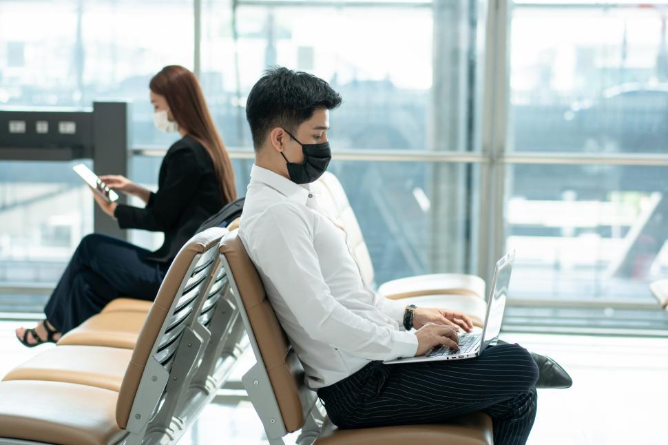 Free Image of Business man wearing medical protective mask working in airport 