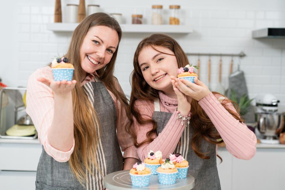Free Image of Mother and daughter showing homemade cupcakes 
