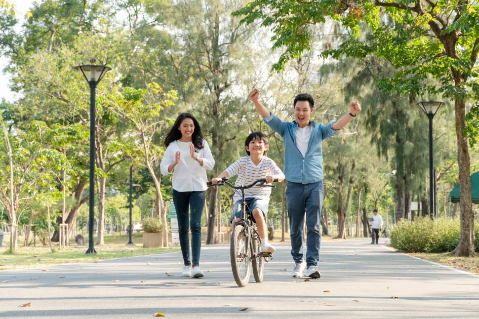 Free Image of Happy  father and mother teach their son to ride a bicycle 