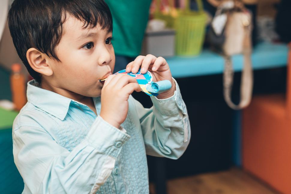 Free Image of Boy blowing horn in birthday party 