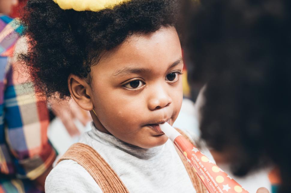 Free Image of African American boy blowing horn in birthday party 