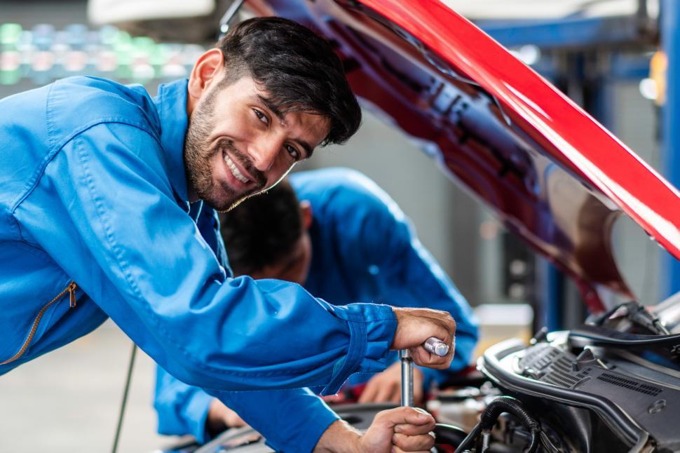 Free Image of Happy mechanic repairing car 
