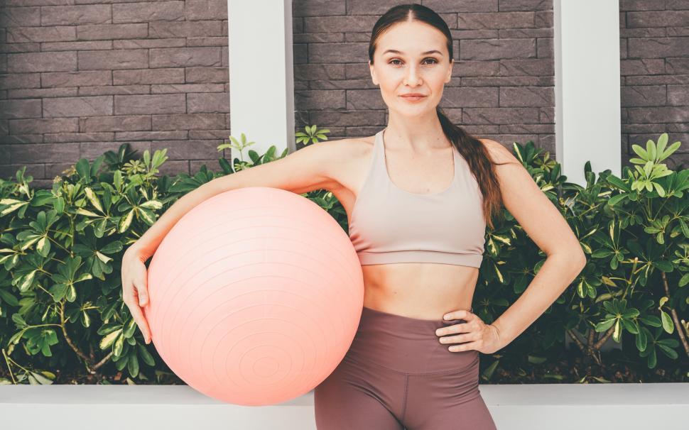 Free Image of Woman in sportswear holding fitness ball. 