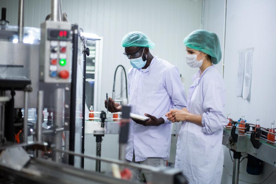 Free Image of Factory worker inspecting drink product on bottling factory 