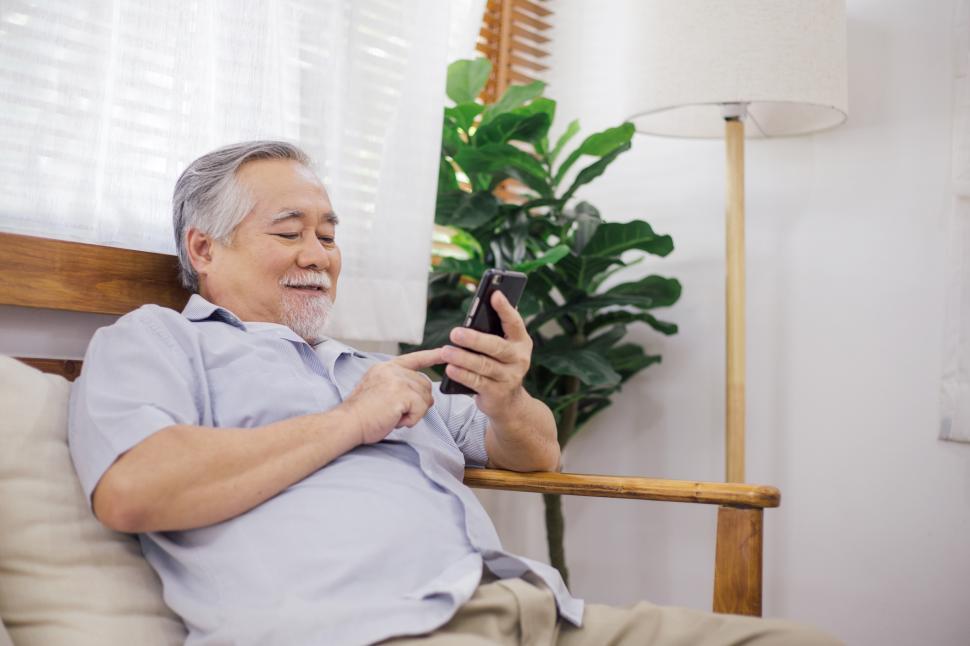 Free Image of Senior man playing mobile phone at home 