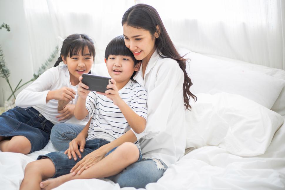 Free Image of Happy family watching movie on smartphone. 