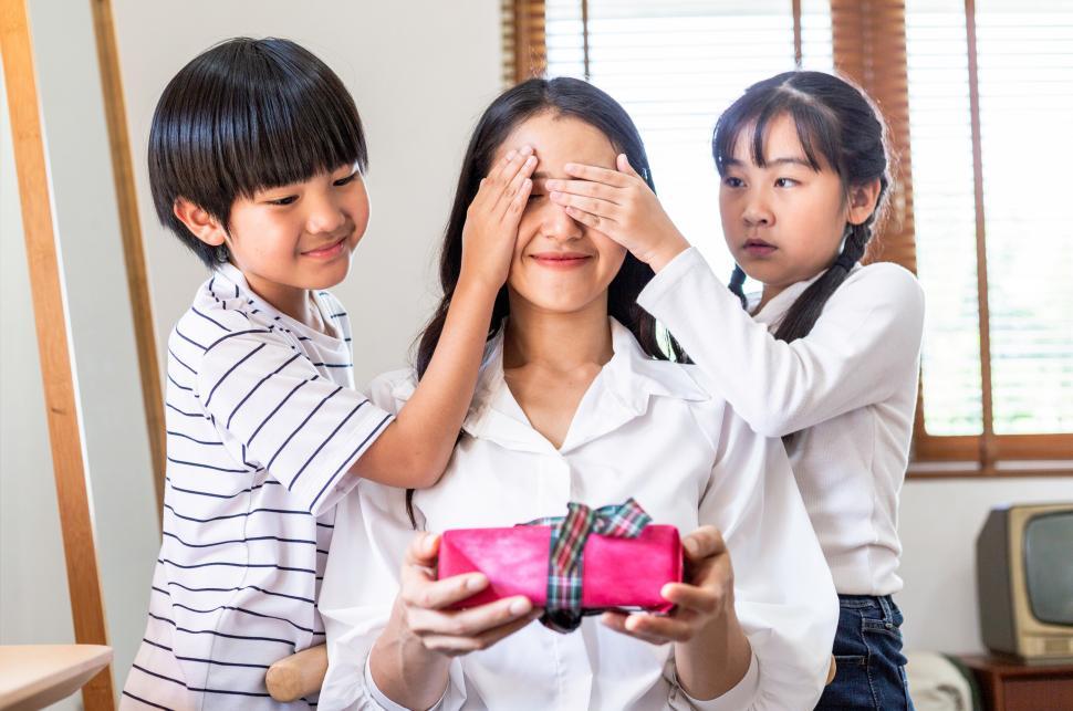 Free Image of Kids covering moms eye to surprise birthday gift 