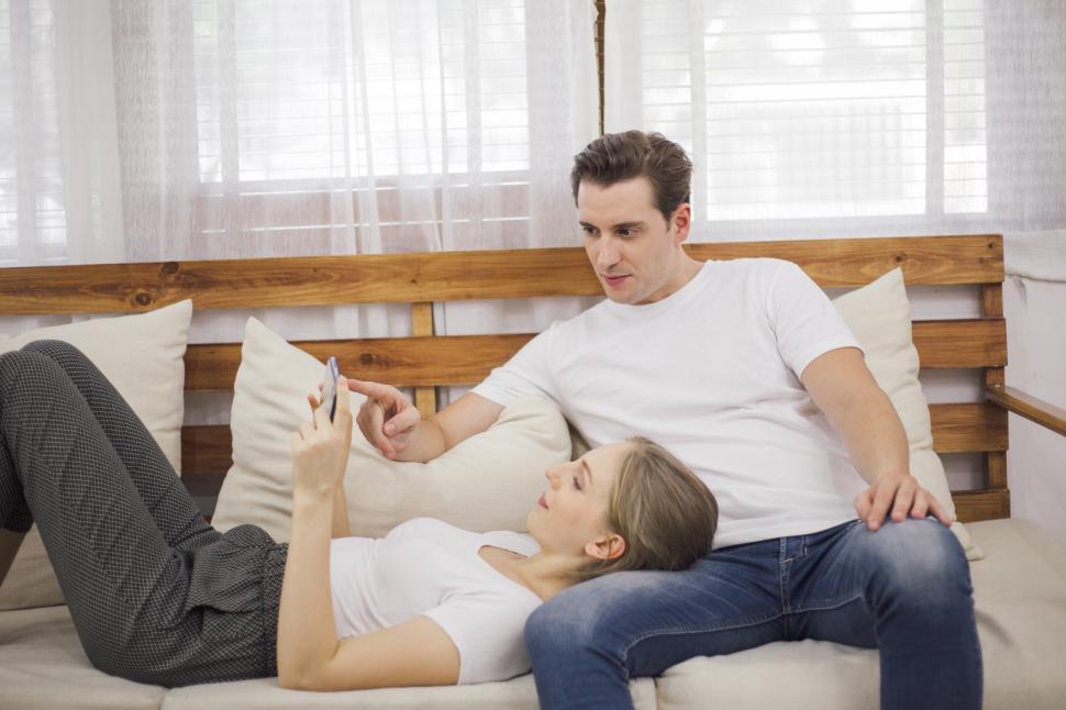 Free Image of Happy couple playing  on mobile phone in the living room 