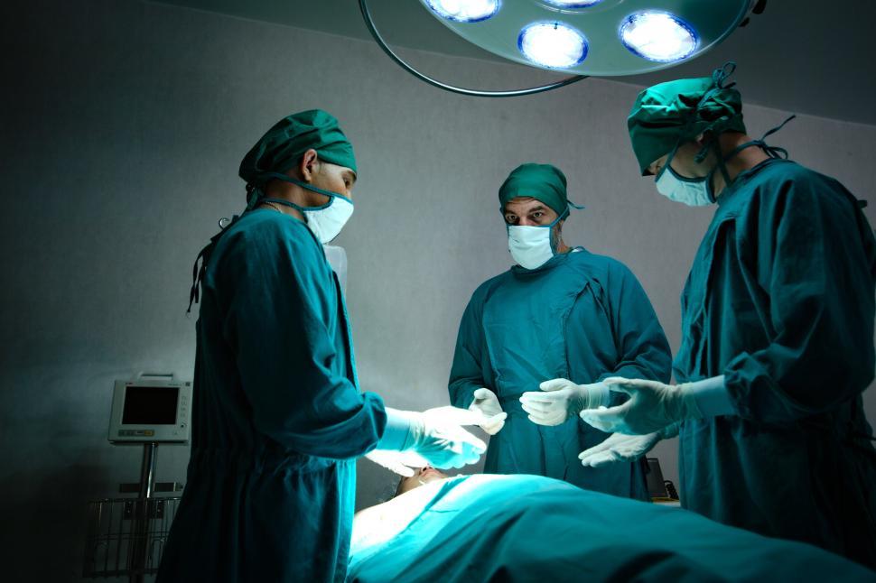 Download Free Stock Photo of Team of surgeons preparing in operating theatre 