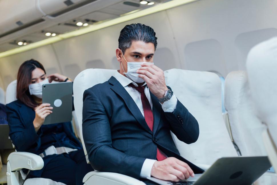 Free Image of Businessman wearing protective mask working on airplane 