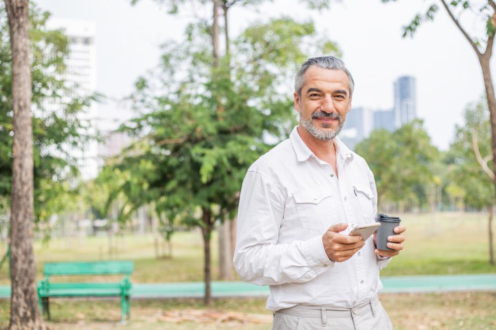 Download Free Stock Photo of Portrait of senior man with coffee at a park 