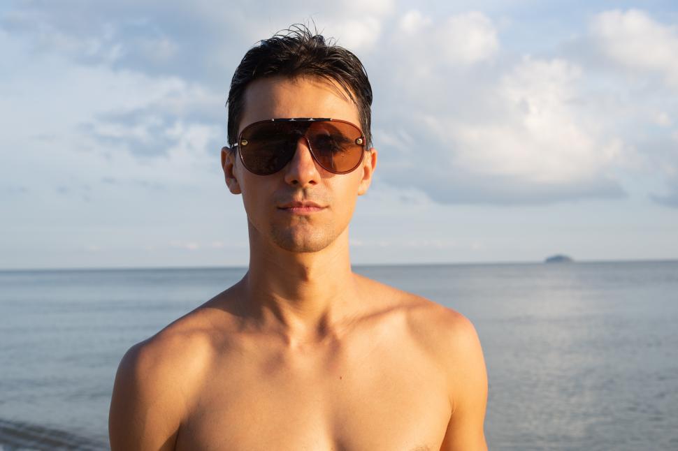 Free Image of Portrait of shirtyless man wearing sunglasses standing in 