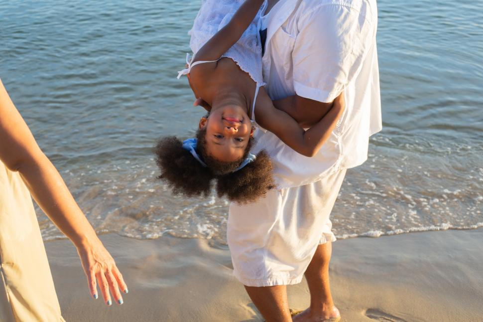 Download Free Stock Photo of Playful father carrying daughter at the beach 