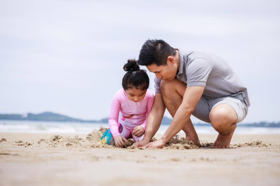Free Image of Happy father and daughter play on the beach. 