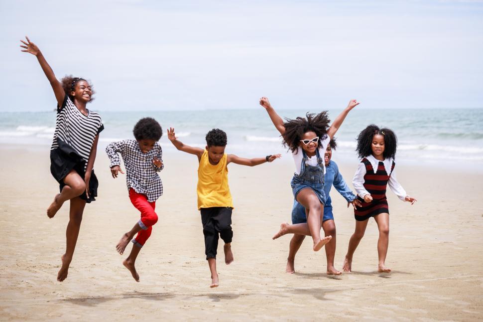 Free Image of Group of kids jumping for joy at the beach 