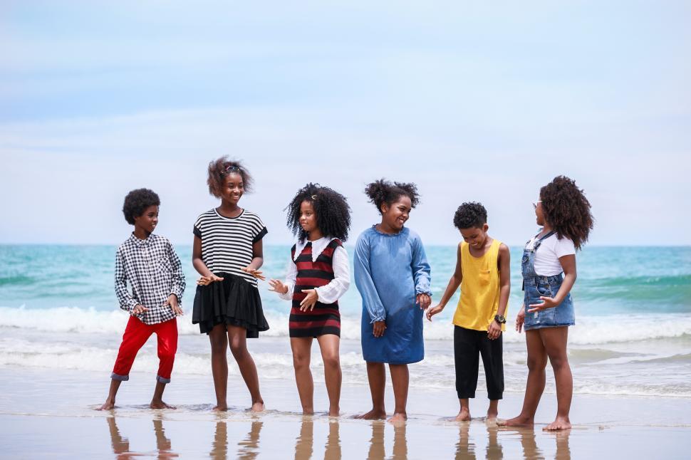 Free Image of Group of kids stand together at the beach 