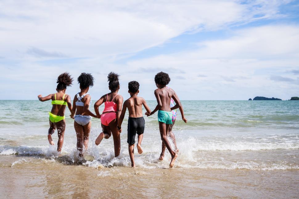 Free Image of Group of kids run to play in the ocean 