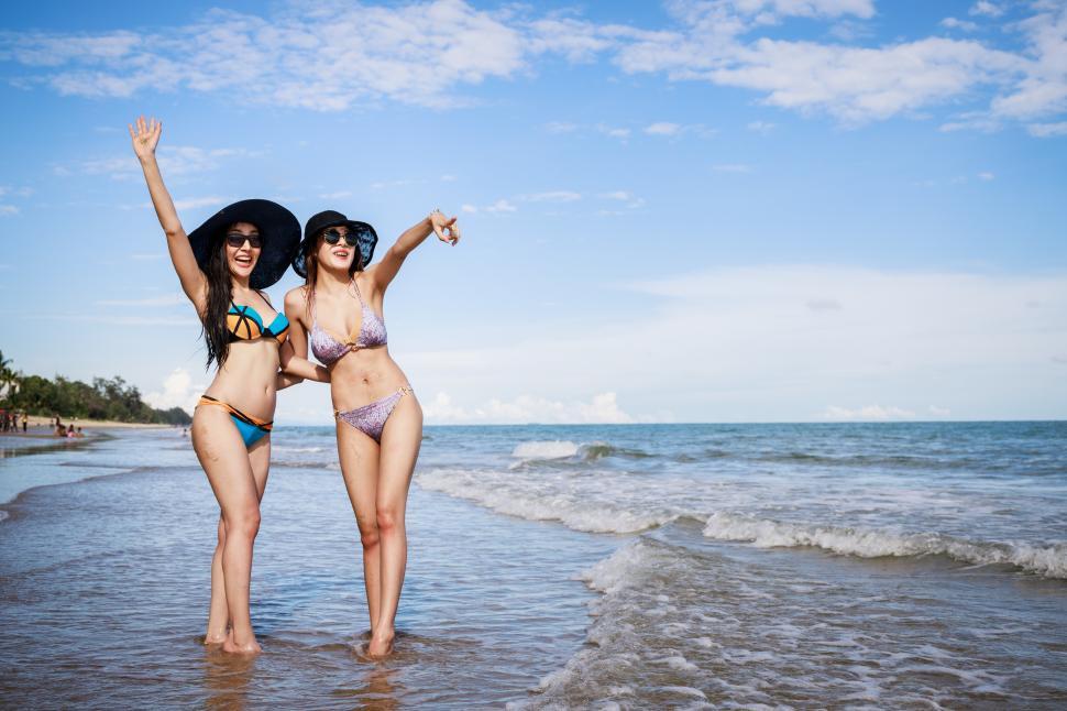 Download Free Stock Photo of Portrait of two attractive young women standing together at the beach 
