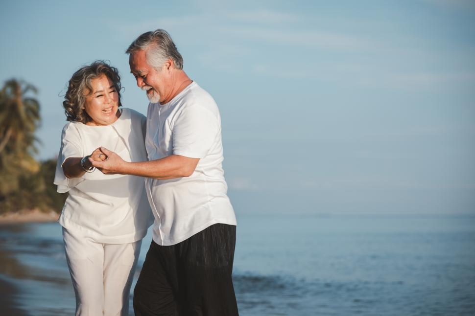 Free Image of The romantic senior couple dancing while standing on summer beach 