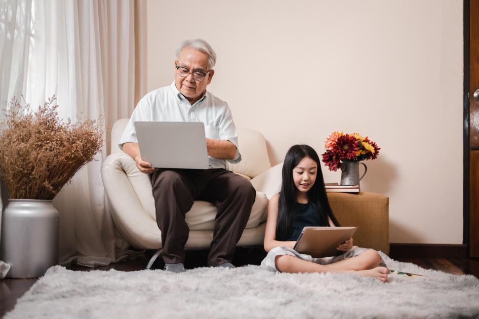 Download Free Stock Photo of Grandfather using a laptop and sitting on sofa 