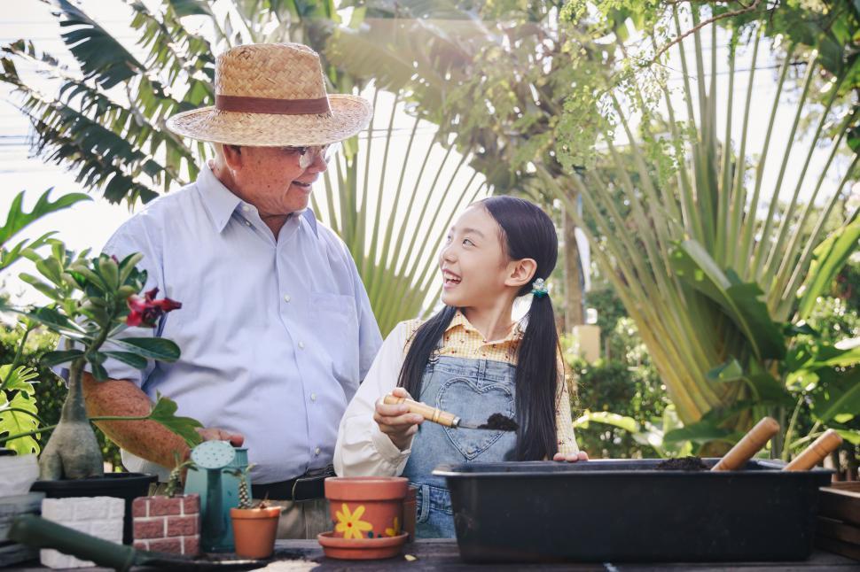 Free Image of Grandfather and granddaughter helping in the garden 
