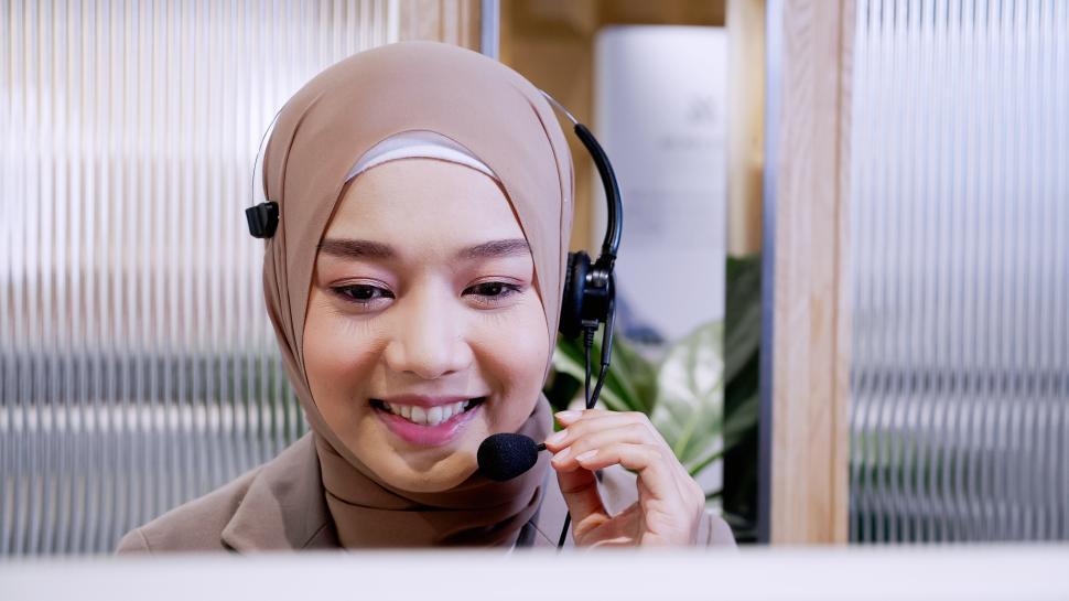 Free Image of Woman in hijab at the computer with headset 