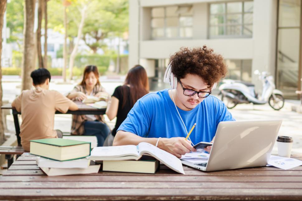 Download Free Stock Photo of College student reading book for exam 