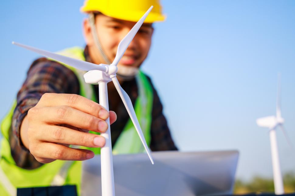 Free Image of Engineer working on wind turbine and solar cell projects. Clean 