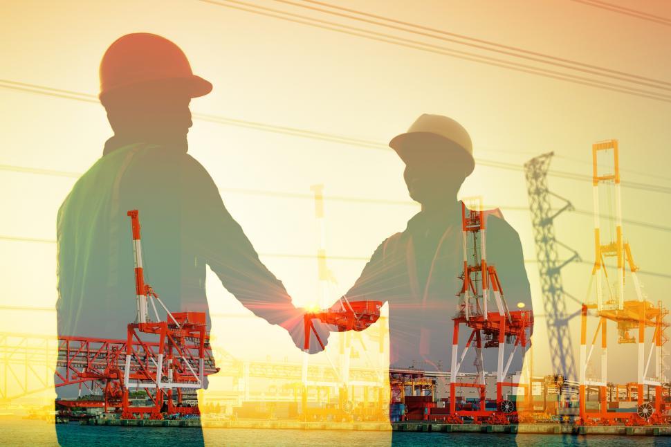 Free Image of Silhouette of two engineers shaking hands in construction site 