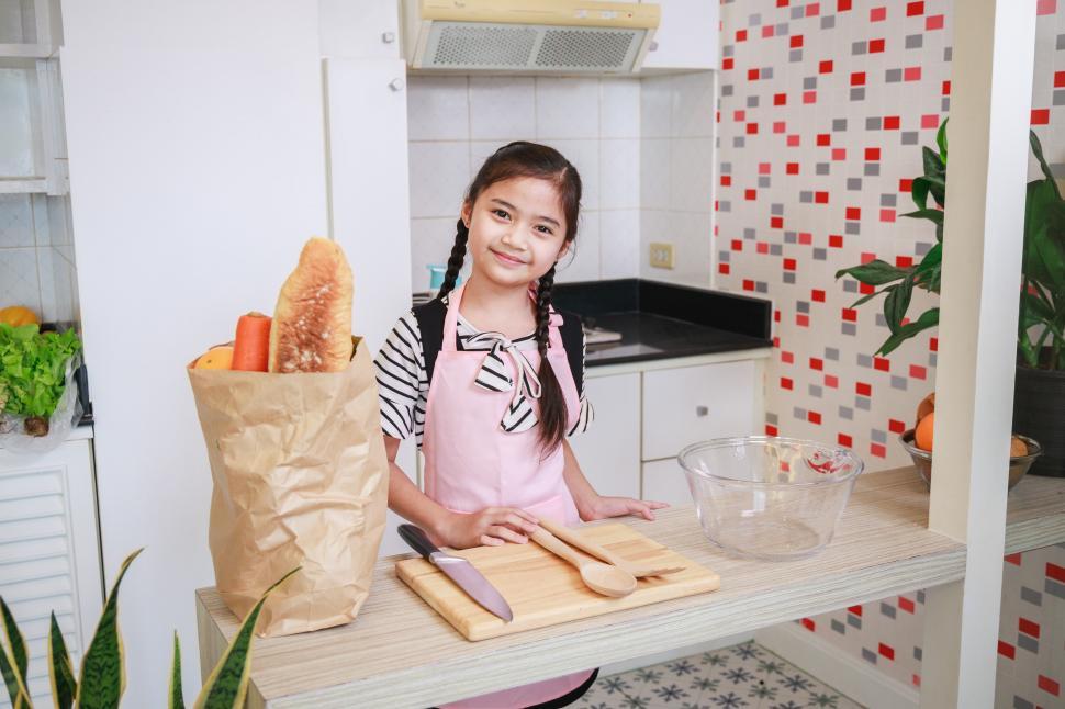 Download Free Stock Photo of Cute kid girl preparing to cook in a kitchen at home 