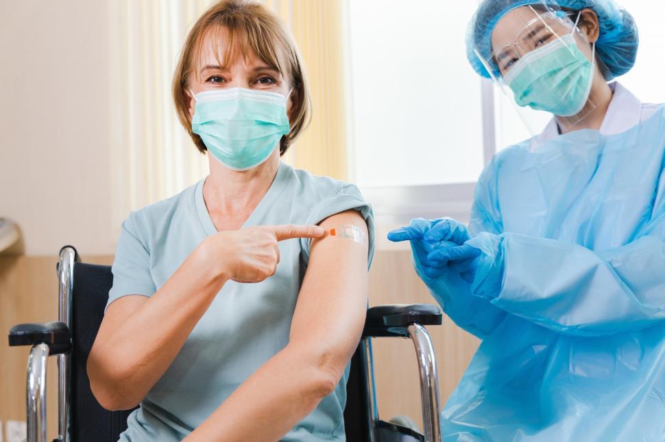 Free Image of Woman pointing to vaccine injection spot 