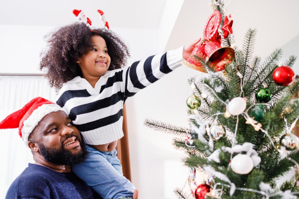 Free Image of Child placing Christmas tree topper 