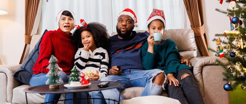 Free Image of Family in Christmas outfits sit on the couch 