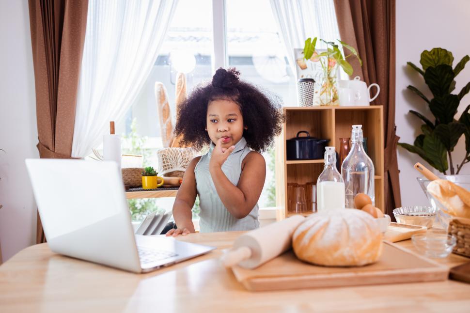 Free Image of Cute kid looking at a recipe online 
